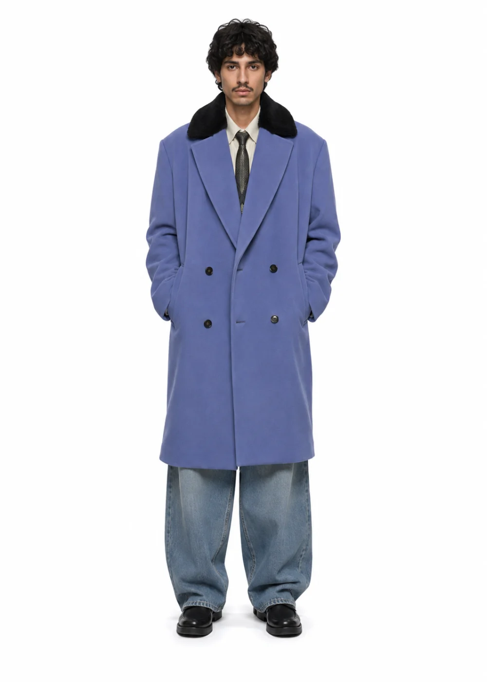 Front view of a man in a blue double-breasted coat with a black collar, grey jeans and black shoes on white.