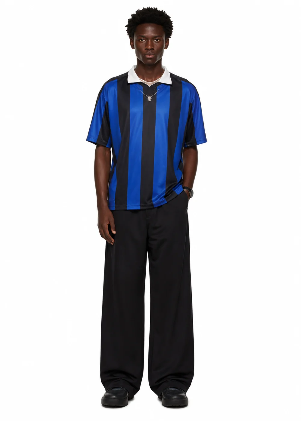 Man in a blue and black striped football shirt with a white collar and black wide-leg trousers, full-length studio shot.