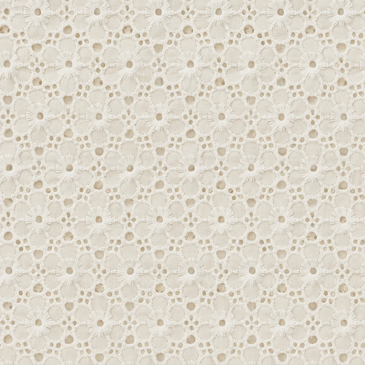 Ivory cotton with embroidered openwork flowers and small eyelet holes, in the style of broderie anglaise.